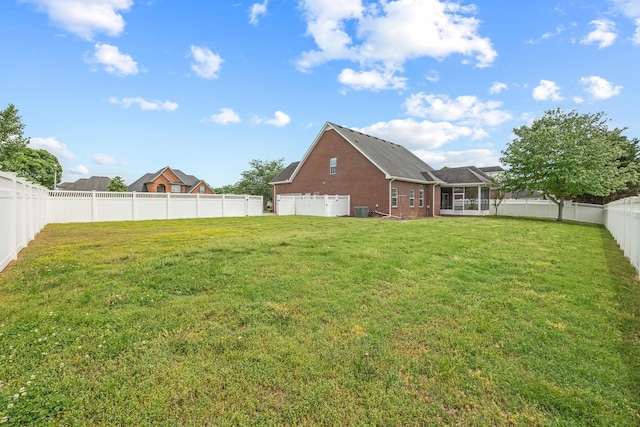 view of yard featuring cooling unit, a fenced backyard, and a sunroom
