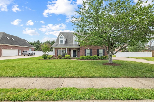 new england style home with driveway, a garage, brick siding, fence, and a front lawn