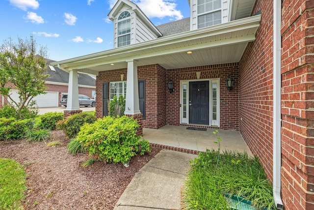 doorway to property with covered porch and brick siding