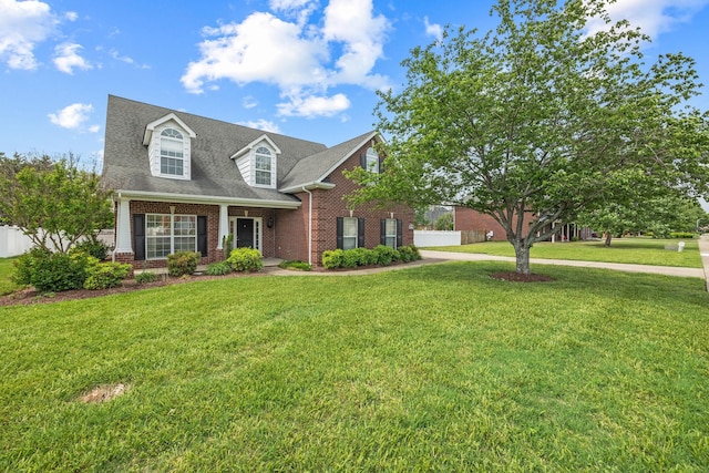 cape cod home featuring brick siding, fence, and a front lawn
