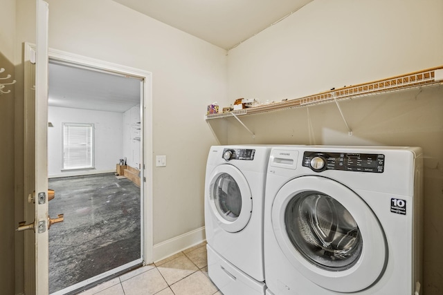 laundry area with laundry area, baseboards, light tile patterned flooring, and washing machine and clothes dryer