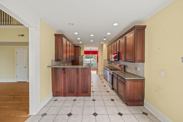 kitchen featuring backsplash, visible vents, appliances with stainless steel finishes, stone countertops, and a peninsula