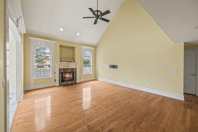 unfurnished living room featuring light wood-style floors, high vaulted ceiling, a ceiling fan, and a healthy amount of sunlight