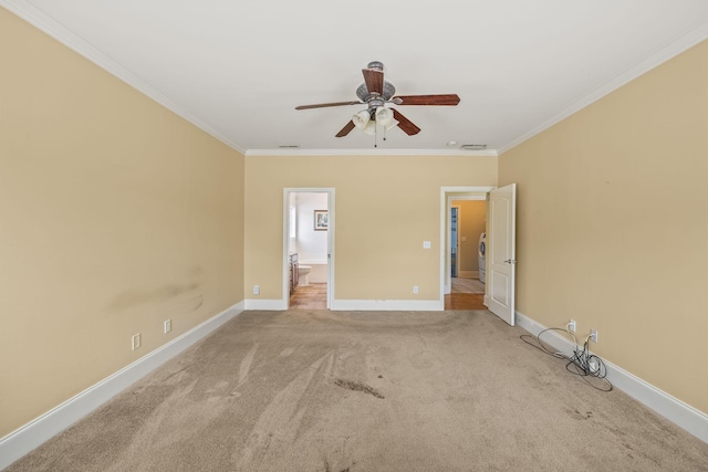 carpeted spare room with crown molding, baseboards, and ceiling fan