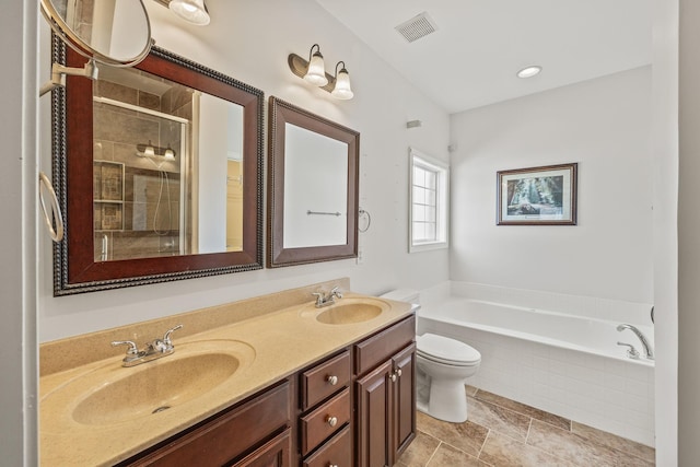 bathroom with double vanity, visible vents, a sink, and a garden tub