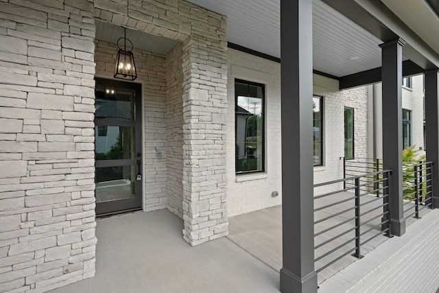 doorway to property with covered porch and brick siding
