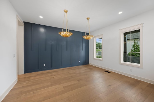 unfurnished dining area with light wood-style floors, baseboards, recessed lighting, and a chandelier
