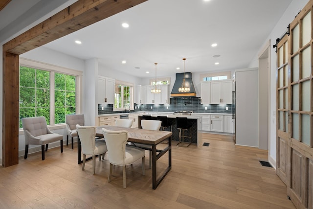 dining area with light wood finished floors, recessed lighting, and a chandelier