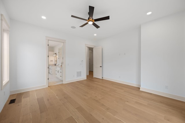 unfurnished bedroom with light wood-type flooring, recessed lighting, baseboards, connected bathroom, and a spacious closet