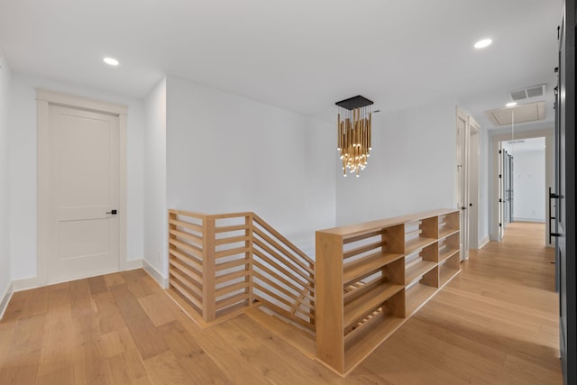 hall with attic access, an upstairs landing, light wood-style flooring, recessed lighting, and baseboards