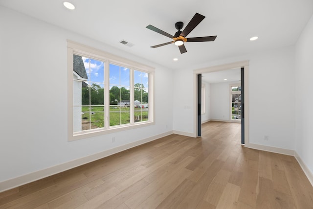 unfurnished room featuring plenty of natural light, light wood finished floors, recessed lighting, a ceiling fan, and baseboards