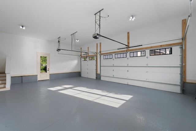 garage with a garage door opener and wainscoting