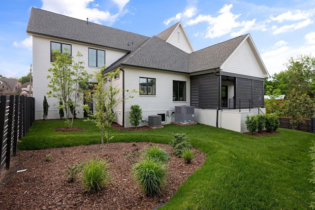 rear view of property with central AC unit, brick siding, and roof with shingles