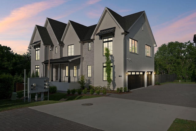 view of front of house featuring decorative driveway, an attached garage, and brick siding