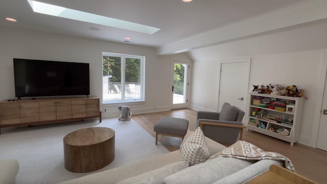 living room with a skylight, baseboards, recessed lighting, and wood finished floors