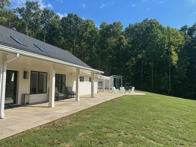 back of property with a patio and a lawn