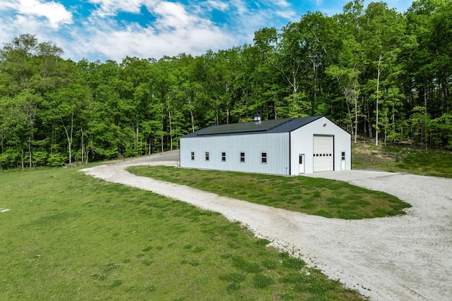 exterior space with gravel driveway and a forest view
