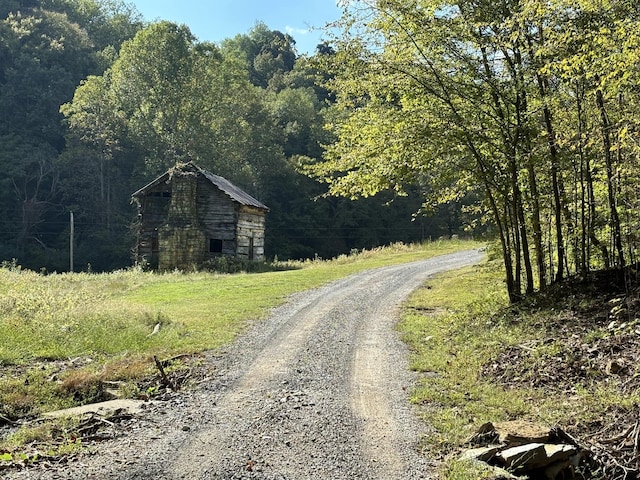 view of street with a barn and a forest view