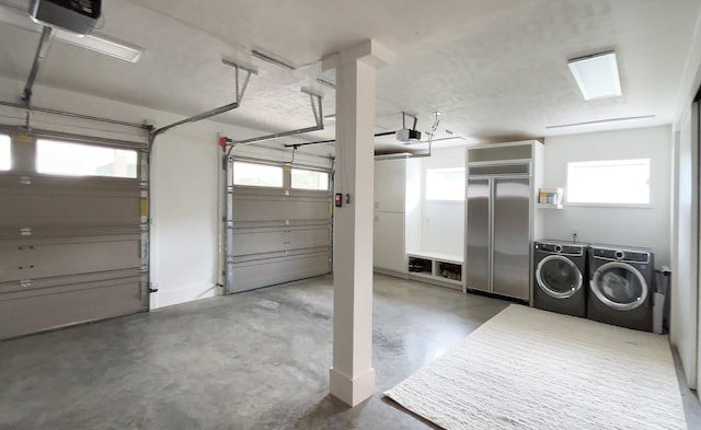 garage featuring built in refrigerator, a garage door opener, and washer and dryer