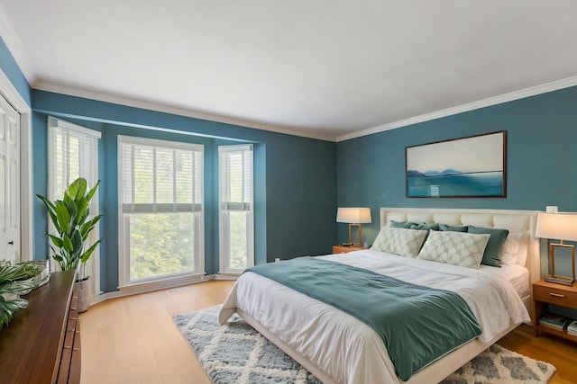 bedroom with crown molding and wood finished floors
