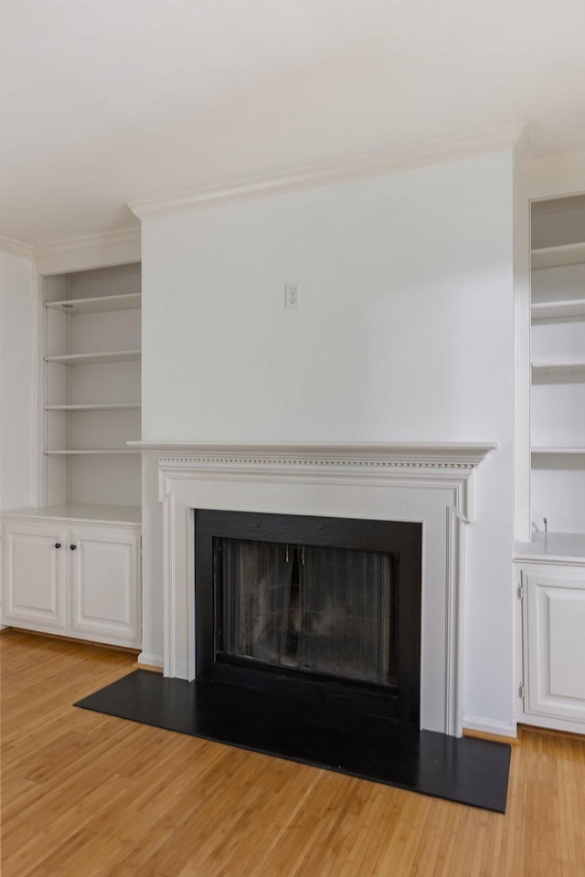 room details with a fireplace with flush hearth, built in features, and wood finished floors