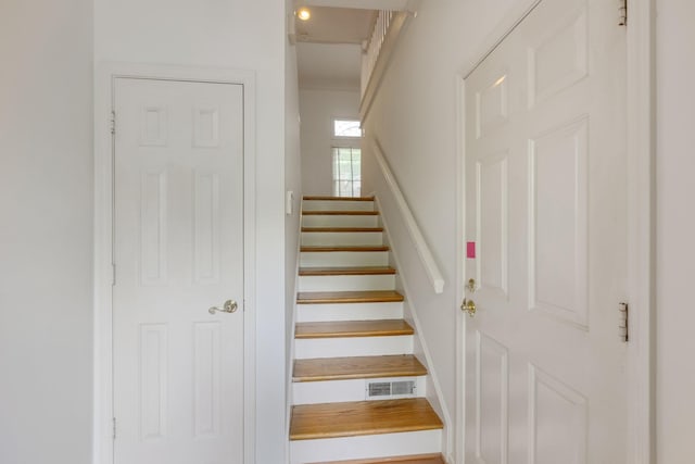 stairs featuring crown molding and visible vents