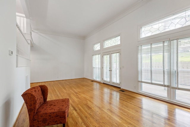 unfurnished room featuring stairs, baseboards, ornamental molding, and wood finished floors