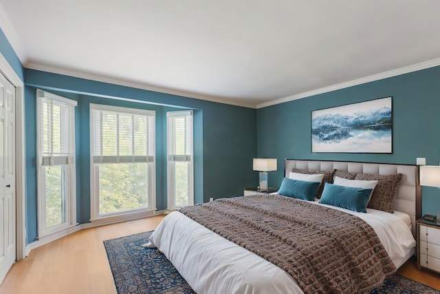 bedroom featuring ornamental molding and wood finished floors
