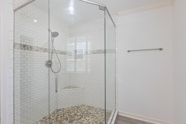 full bath with crown molding and a stall shower