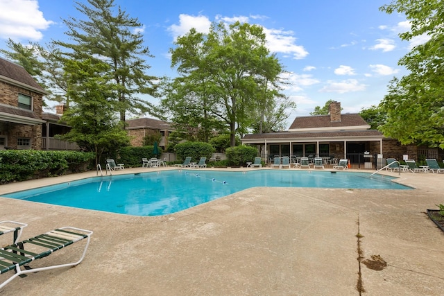 community pool with fence and a patio