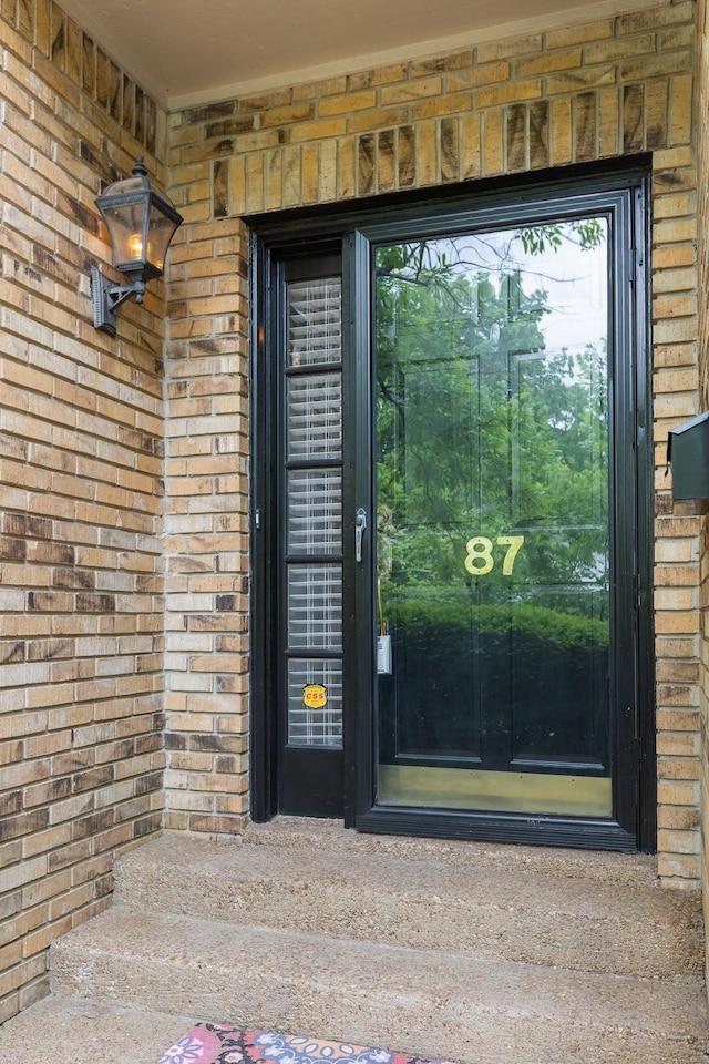 doorway to property with brick siding