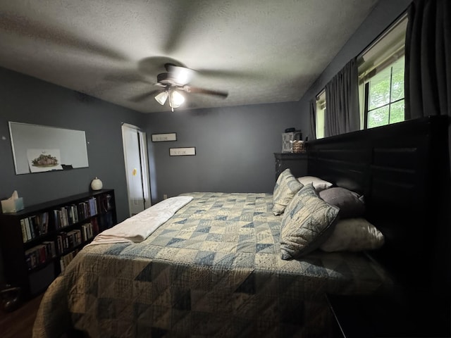 bedroom with a ceiling fan and a textured ceiling