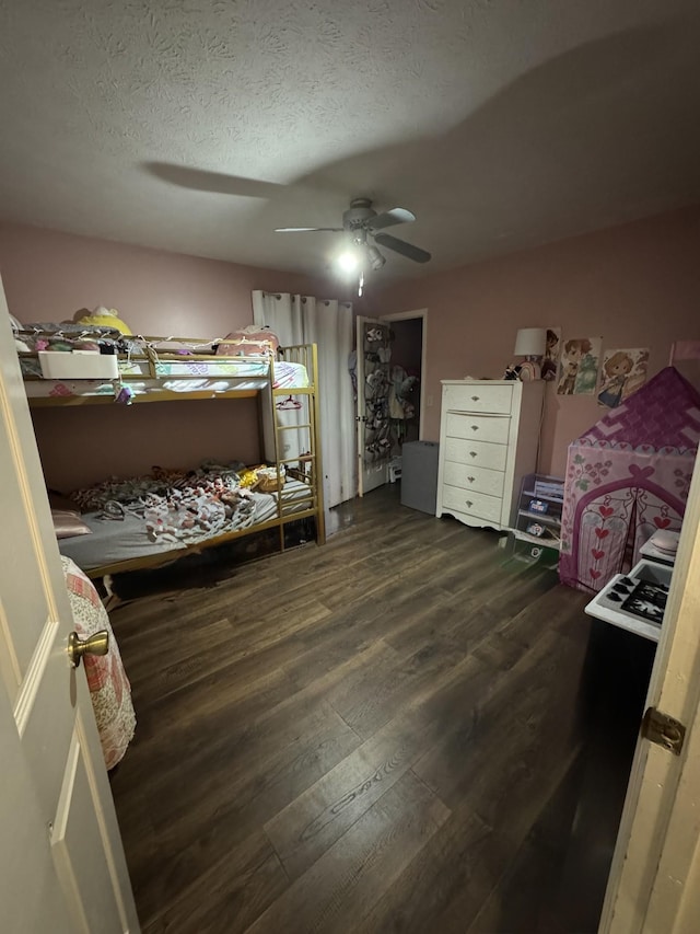 bedroom featuring a ceiling fan, dark wood-style floors, and a textured ceiling