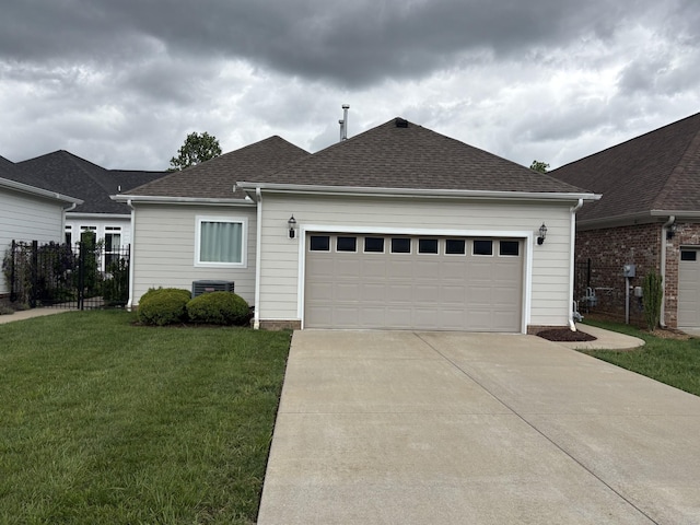 ranch-style home with fence, roof with shingles, a garage, a front yard, and driveway