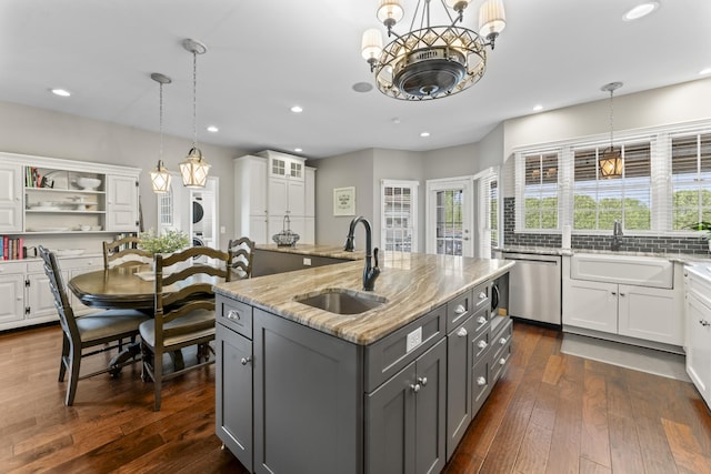 kitchen featuring stainless steel dishwasher, a sink, white cabinets, and gray cabinetry