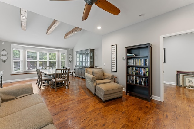 living room with baseboards, ceiling fan, wood finished floors, and lofted ceiling