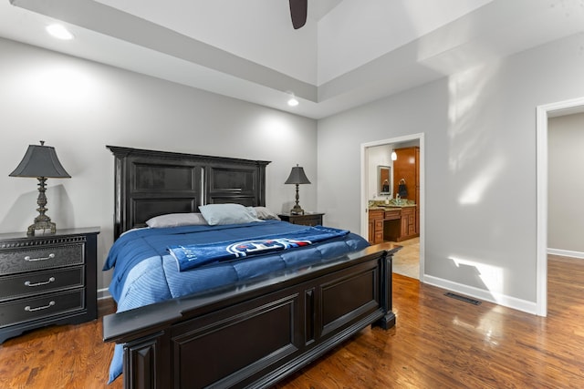 bedroom with baseboards, dark wood-style flooring, ensuite bath, and visible vents