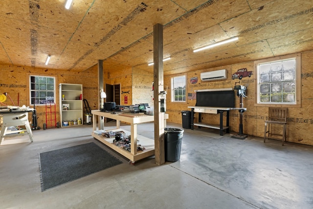 interior space with concrete floors, a workshop area, and a wall unit AC