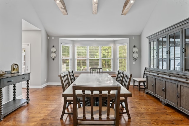 dining room with baseboards, wood finished floors, and lofted ceiling