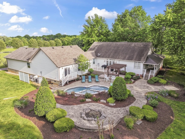 rear view of property featuring a pergola, a shingled roof, an outdoor pool, a lawn, and a fire pit