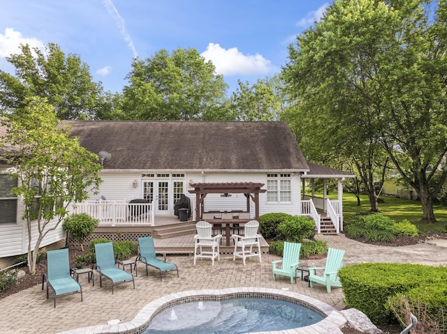 rear view of property with a wooden deck, a shingled roof, a pergola, and a patio area
