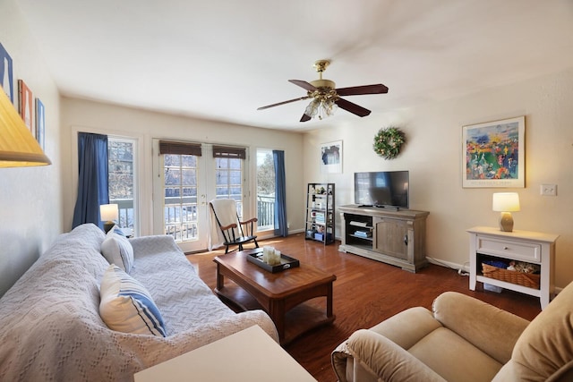 living room featuring baseboards, a ceiling fan, and wood finished floors