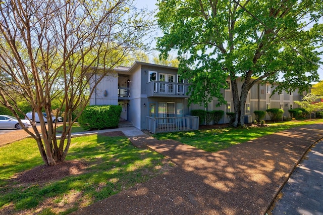 view of front facade with a front lawn and a balcony