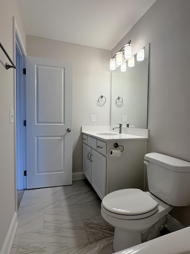 half bath featuring toilet, baseboards, marble finish floor, and vanity
