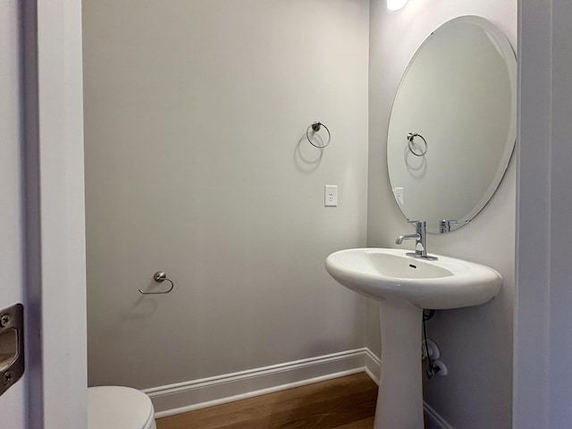 bathroom featuring baseboards, toilet, and wood finished floors