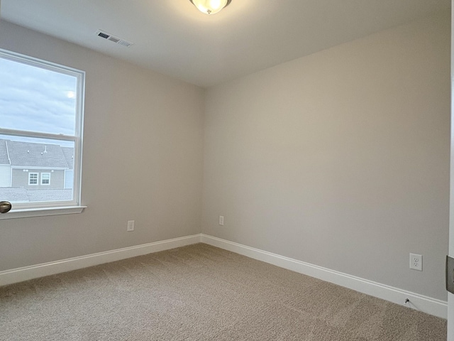 unfurnished room with visible vents, carpet, and baseboards