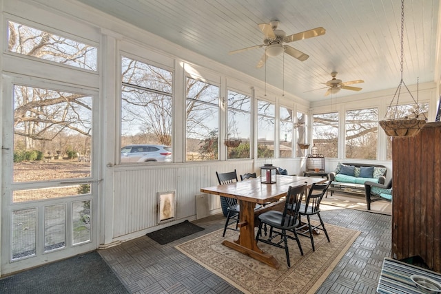 sunroom with outdoor dining area, ceiling fan, and an outdoor living space