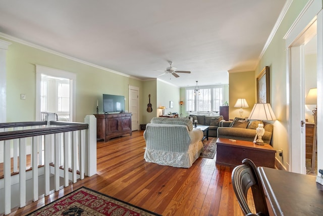 living room with wood-type flooring, a ceiling fan, and crown molding