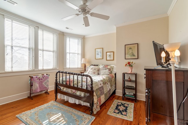 bedroom featuring baseboards, visible vents, ornamental molding, and wood finished floors