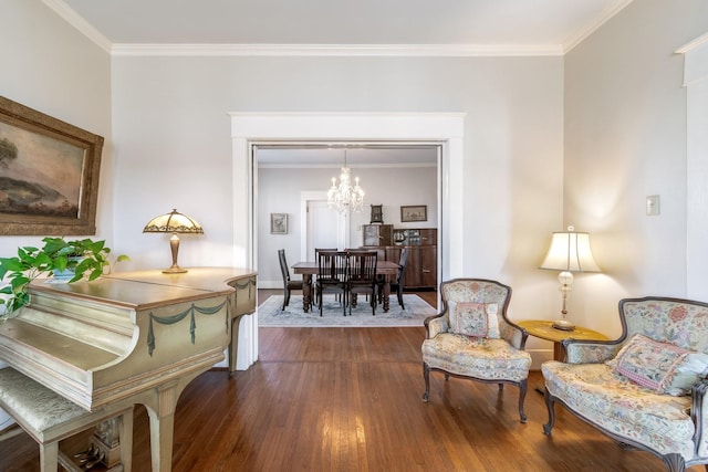 living area featuring an inviting chandelier, baseboards, ornamental molding, and dark wood-type flooring